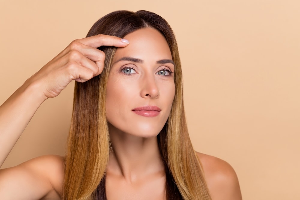 Woman pointing to her forehead